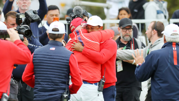 Tiger Woods embraces teammates after victory was assured.