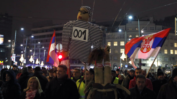 People hold a effigy representing Serbian President Aleksandar Vucic dressed as a prisoner, during a protest in Belgrade, Serbia, on Saturday.