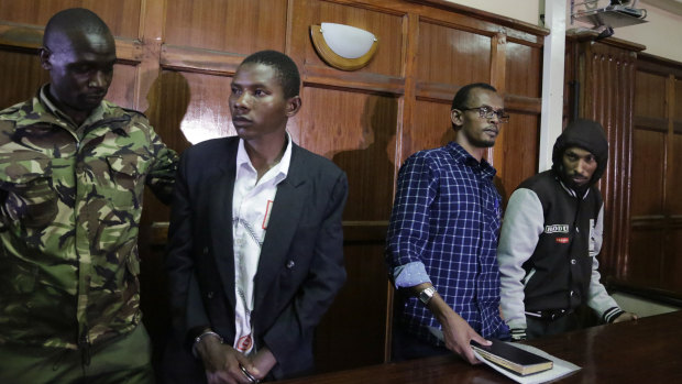 From left to right, defendants Rashid Charles Mberesero, Hassan Aden Hassan and Mohamed Abdi Abikar, are led from the dock by a police officer, left, after their verdict at a court in Nairobi, Kenya, on Wednesday.