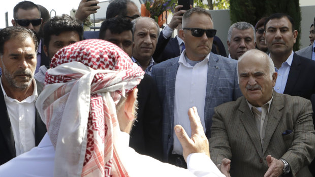 His Royal Highness Prince El Hassan bin Talal Hashemite, right, of Jordan, greets a worshipper  outside the Al Noor mosque in Christchurch, New Zealand, on Saturday.