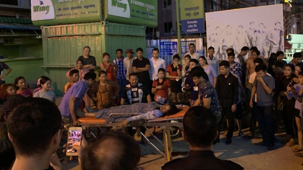 A woman is tended to after she was assaulted in a casino carpark in Sihanoukville, Cambodia.