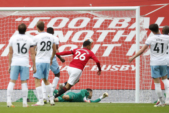 Manchester United's Mason Greenwood scores his side's opening goal during the English Premier League soccer match between Manchester United and West Ham. 