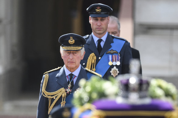 King Charles III and Prince William, the Prince of Wales, walk behind the coffin.