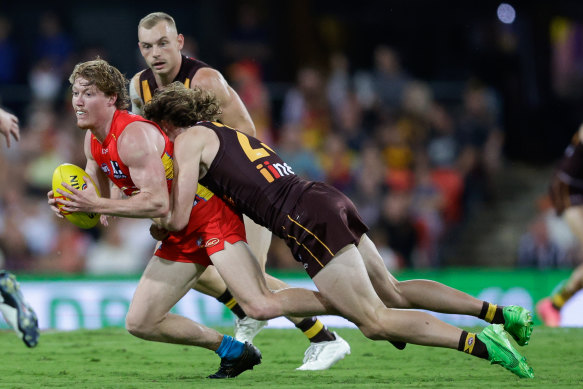 Matt Rowell of the Suns is tackled by Josh Weddle of the Hawks.