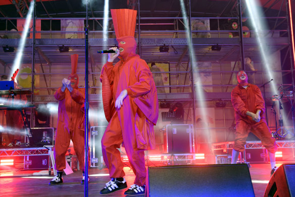 Dressed in red coveralls and matching balaclavas with red foam mohawks,TISM look like alien priests.