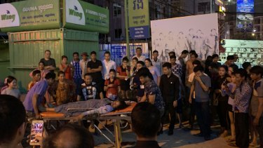 A woman is tended to after she was assaulted in a casino carpark in Sihanoukville, Cambodia.