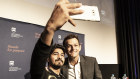 A university student takes a selfie with retired cricketer Adam Gilchrist.