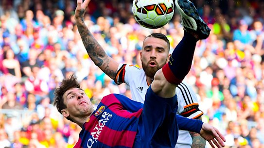 Lionel Messi tussles with Valencia's Nicolas Otamendi during a 2015 La Liga clash.