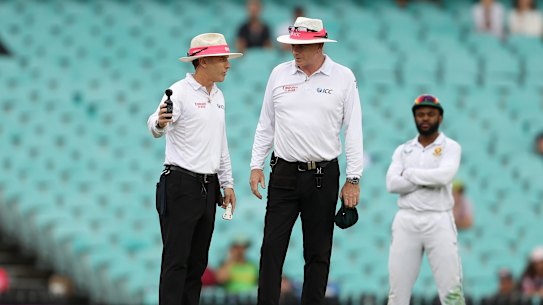 Umpires Chris Gaffaney and Paul Reiffel consult the light meter during the Sydney Test.