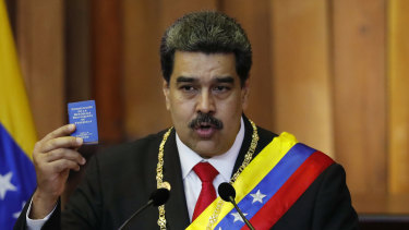 Nicolas Maduro with a tiny copy of the constitution during his swearing in as president on January 10.