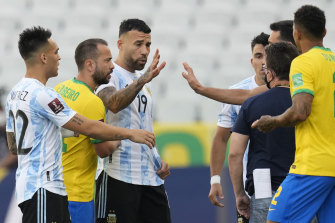 Brazil and Argentina players talk as the game is interrupted by health authorities.