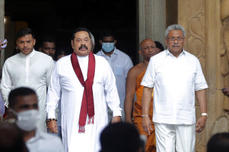 Sri Lanka’s outgoing Prime Minister Mahinda Rajapaksa, centre, leaves with his younger brother, President Gotabaya Rajapaksa, right, after being sworn in as the prime minister at Kelaniya Royal Buddhist temple in Colombo, Sri Lanka, August 9, 2020. 