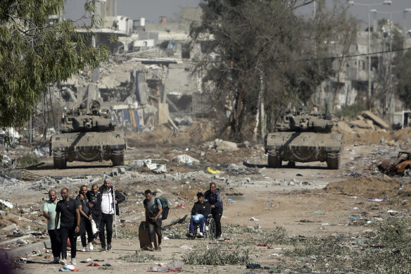 People flee from northern Gaza as Israeli tanks block a road last November.