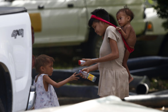 A Yanomami boy interacts with a Yanomami woman carrying a baby at the Saude Indigenous House, a support centre in Boa Vista, Roraima state, Brazil, on Wednesday.