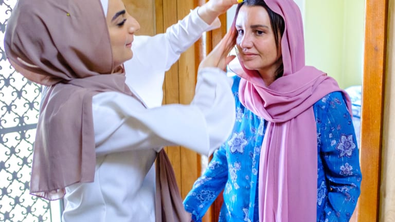 Jacqui Lambie tries on a head scarf while filming Go Back To Where You Came From Live.