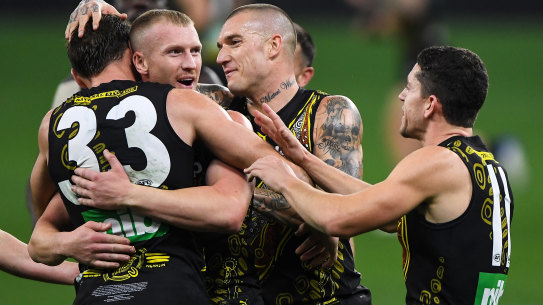 Kamdyn McIntosh, Josh Caddy and Dustin Martin celebrates a goal.