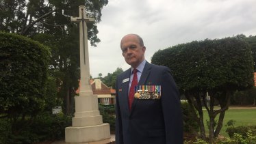 Toowong RSL branch president Kerry Gallagher AM  at the restored Cross of Sacrifice at Toowong Cemetery.