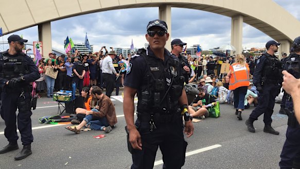 Police move in to clear people from the bridge.