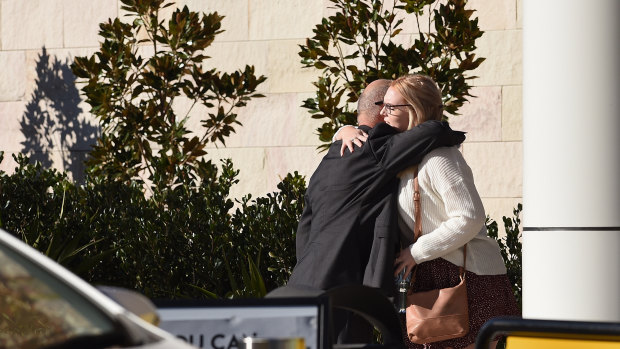 Mr Brosnan's father, Cornelius (left), embraces his son's girlfriend, Hayley Sheers, outside the NSW Coroners Court.