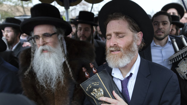 Orthodox Jews in Monsey, New York,  celebrate the arrival of a new Torah a day after an attack on their community.
