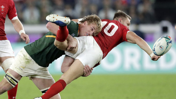 Wales' Dan Biggar, right, passes while being tackled by South Africa's Pieter-Steph du Toit. 