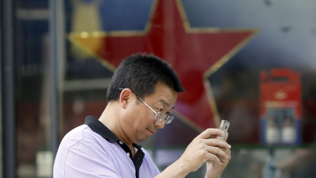 The Iran-US war for opinion is unfolding in an unlikely place: China's internet. A man uses his mobile phone near in Beijing.
