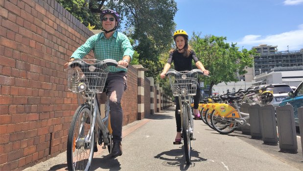Brisbane Council deputy mayor Adrian Schrinner and Bicycle Queensland chief executive Anne Savage ride around Mater Hospital in Annerley, where a new CityCycle station has been installed.