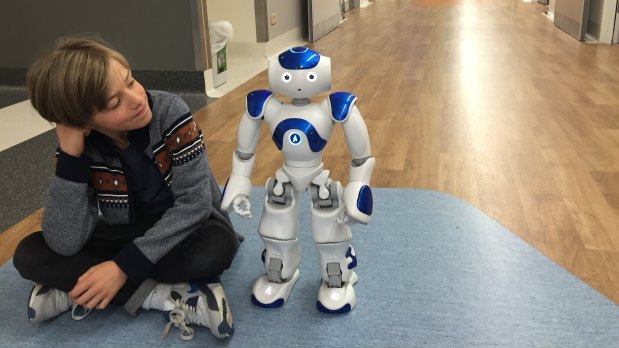 Nine-year-old Luka Milenkovic with MEDIZen, the new $25,000 robot for the Canberra Hospital which was paid for by fundraising within the local hospitality industry.