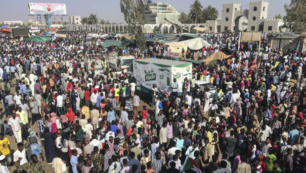 Sudanese demonstrators march with national flags as they gather during a rally demanding a civilian body to lead the transition to democracy, outside the army headquarters in the Sudanese capital Khartoum on Saturday.