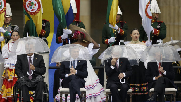 From left, Ecuador's President Lenin Moreno, Argentina's Mauricio Macri, Chile's Sebastian Pinera and Mexico'sEnrique Pena Nieto hold umbrellas during the presidential inauguration of Ivan Duque, in Bogota, Colombia.