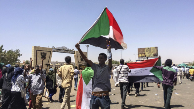 Protester display Sudanese flags at a rally in front of the military headquarters in the capital Khartoum, Sudan.