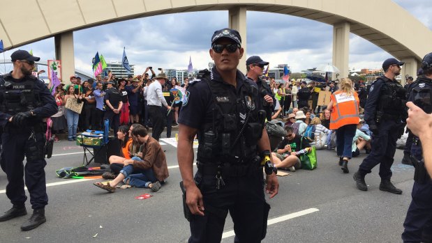 Police move in to clear people from the bridge.