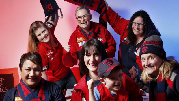 Melbourne diehard fan Sophie Galer (centre), her son Ben Harrison and their  fellow Demon Army supporters.