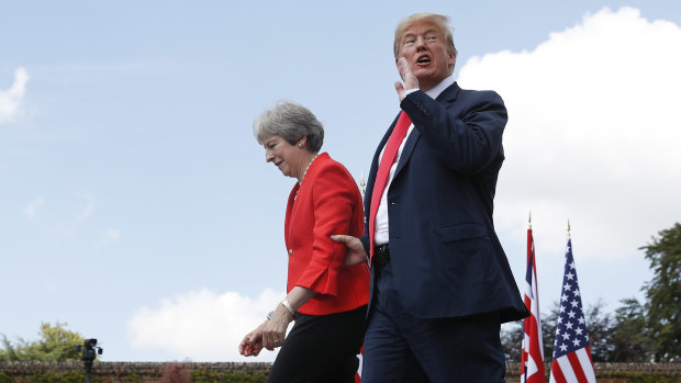 President Donald Trump responds to a reporter's shouted questions as he walks with British Prime Minister Theresa May at the conclusion of their joint news conference at Chequers.