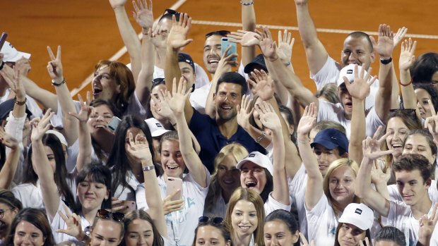 Serbia's Novak Djokovic, centre, poses with volunteers and players after the tournament in Belgrade on June 14.