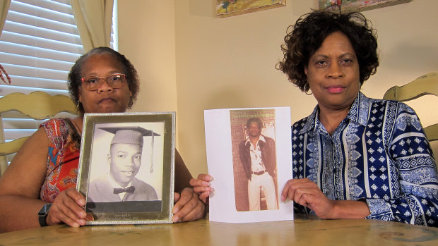 Mylinda Byrd Washington, 66, right, and Louvon Byrd Harris, 61, hold up photographs of their brother James Byrd jnr.