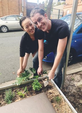 Compost contributors Niklas Olsson and Julia Di Kang plant mint around Vikki Tennant's compost.