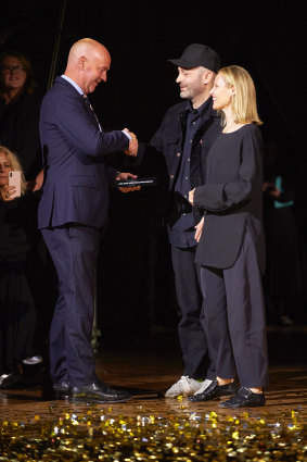Woolmark Prize womenswear winners Michael (centre) and Nicole Colovos, of Colovos, accept their prize from Woolmark chief Stuart McCullough.