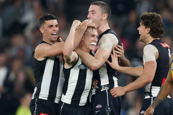 Collingwood’s Joe Richards, middle, is mobbed by his teammates after kicking his first AFL goal.