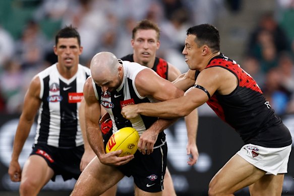 Steele Sidebottom of the Magpies is tackled by Dylan Shiel of the Bombers.