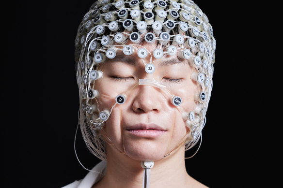 Shijing Zhou, research lab manager at the Brain Electrophysiology Lab, wears a geodesic head web device that does high-definition EEG collection. The company is also working on an experimental electrode cap that helps with deep sleep. 