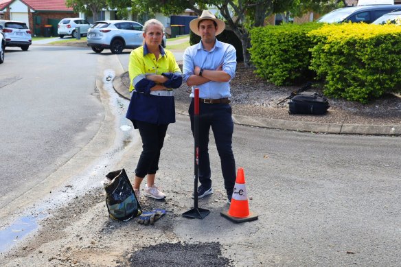 Labor’s mayoral candidate Tracey Price fills a pothole at Tingalpa with Labor’s Doboy ward candidate Alex Cossu.