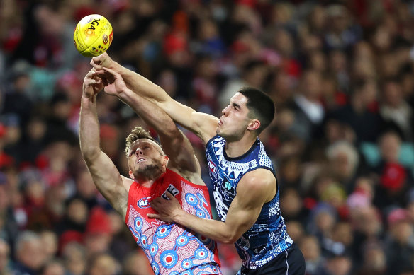 Luke Parker of the Swans attempts to take a mark as Adam Cerra of the Blues punches the ball.