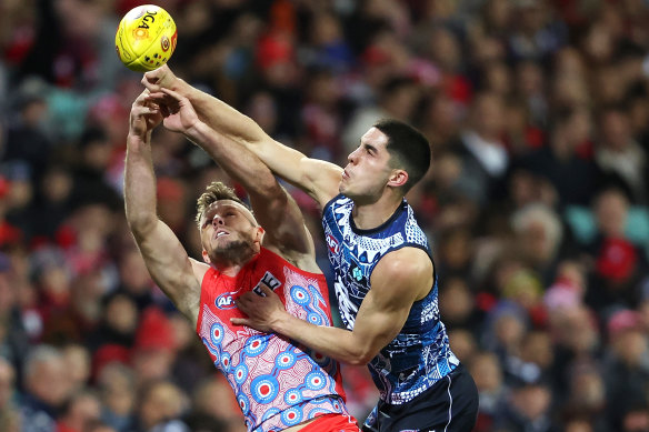 Luke Parker of the Swans attempts to take a mark as Adam Cerra of the Blues punches the ball.