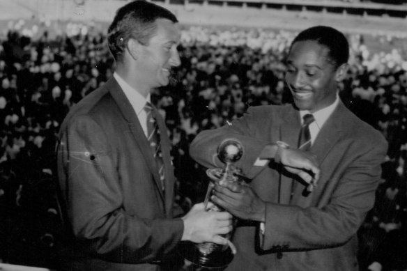 West Indian captain Frank Worrell (right) uses his sleeve to put a final polish on the Frank Worrell Trophy, before he presented it to Australian captain Richie Brand.