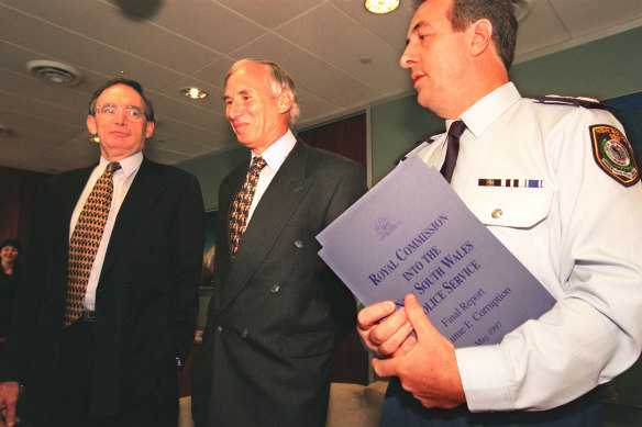 Justice James Wood (centre) hands over his royal commission report into NSW Police to premier Bob Carr in 1997. Police commissioner Peter Ryan holds the report.