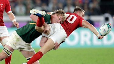 Wales' Dan Biggar, right, passes while being tackled by South Africa's Pieter-Steph du Toit. 