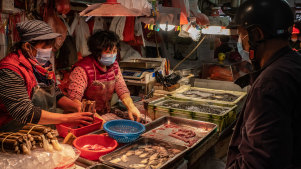 Residents wearing face mask buy seafood at a wet market in China.