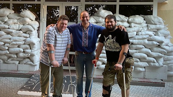 Aid workers Shaun Hopkins and Yaroslav Kolodiy with surgeon Volodymyr Grygorovskyy after delivering medical supplies to a Kyiv hospital in July 2022.