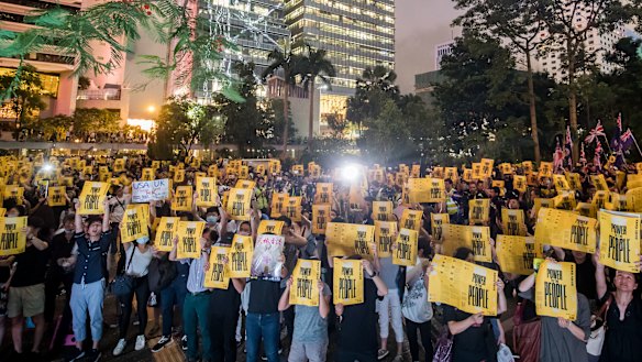 Demonstrators hold signs during the Stand with Hong Kong, Power To The People Rally at Chater Garden in Hong Kong, China.